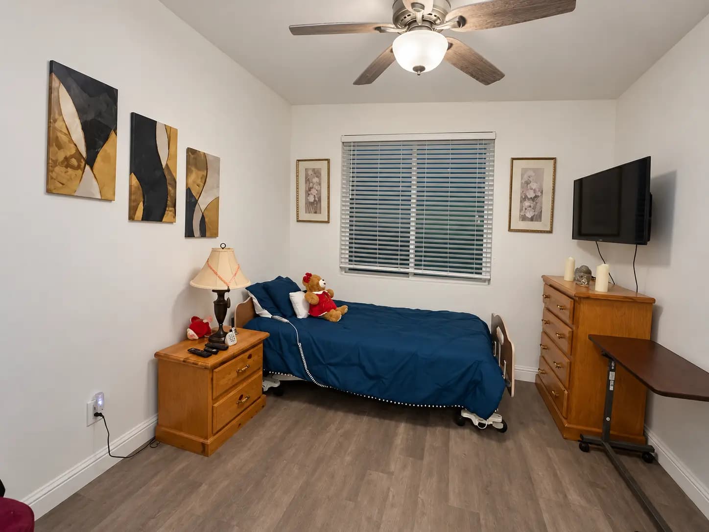 Laurite bedroom with a blue bedspread, bedside table and dresser